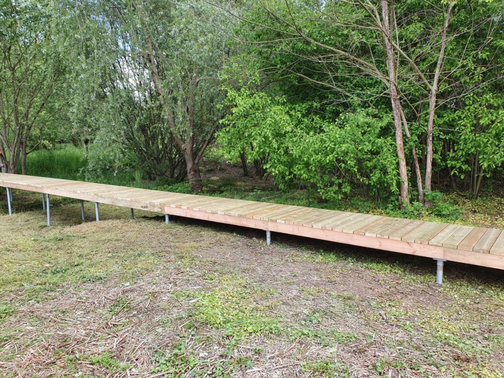 Cheminement et passerelle en platelage bois installé sur pieux métalliques en guise de fondation